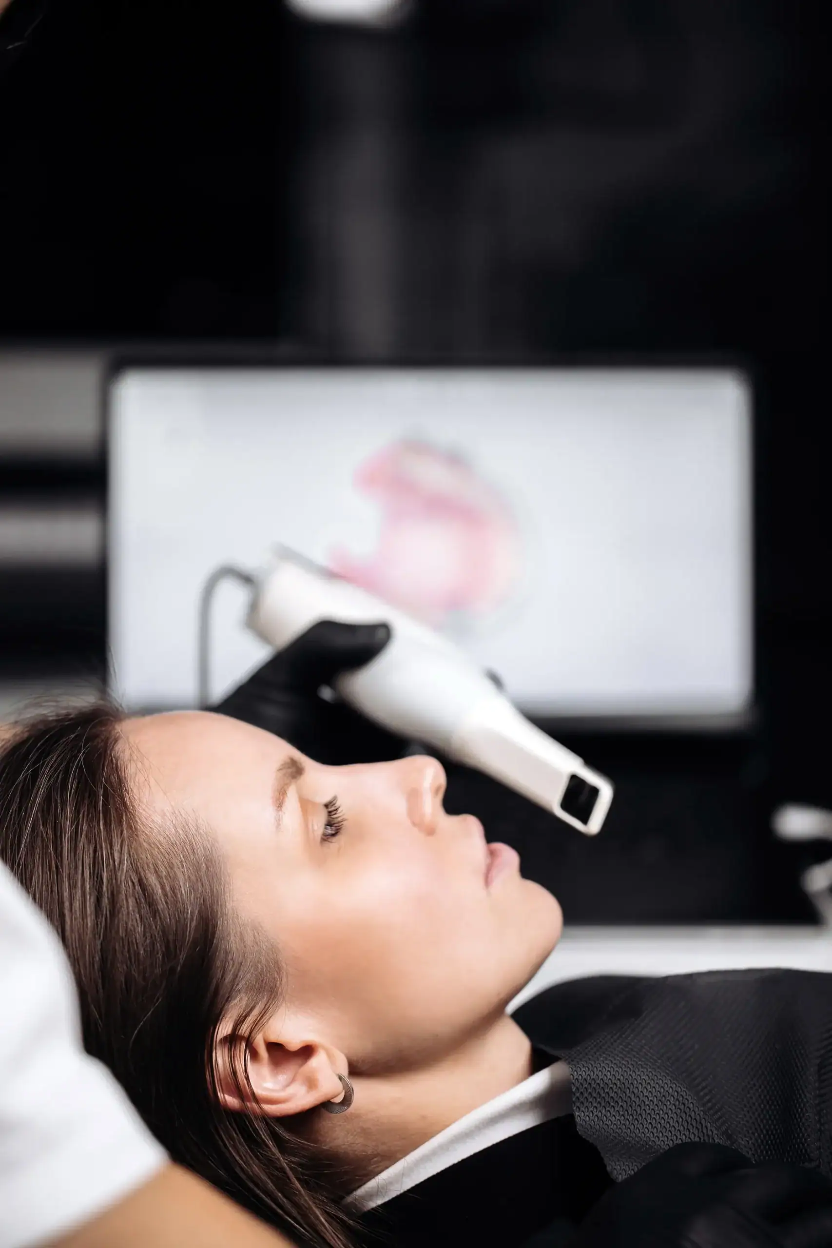 Digitale Kieferorthopädie - Abbildung: Frau, Intraoralscanner, Monitor mit Scan